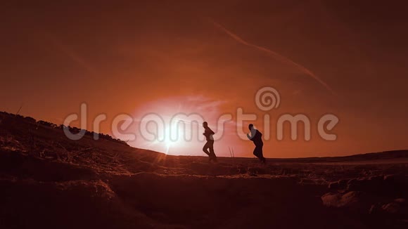 跑步者两个人在沙滩上奔跑夕阳西下赛跑者视频的预览图
