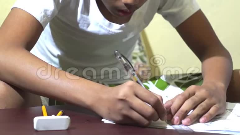 亚洲男孩学习和练习在棕色书桌上的笔记本上画3D形状视频的预览图
