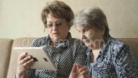两个女人在数码平板电脑上看照片视频的预览图