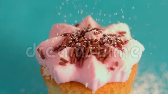 把冰糖筛在粉红色的糖霜蛋糕上视频的预览图
