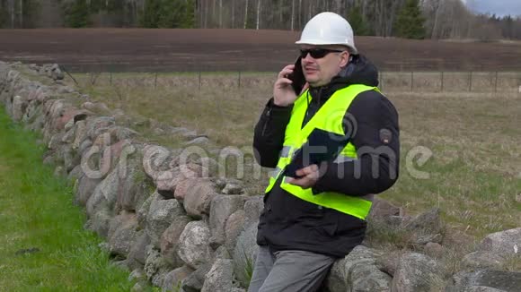 土木工程师在新建筑工地的地方用智能电话交谈视频的预览图