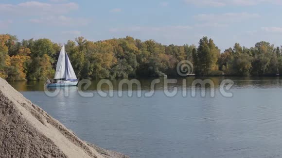 秋天白色的帆船在大坝旁漂浮视频的预览图