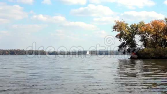 秋天白色的帆船在大坝旁漂浮视频的预览图