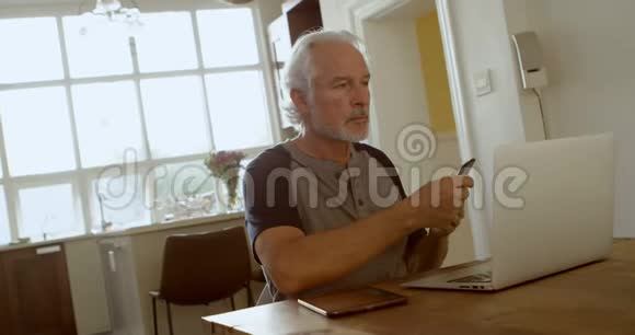坐在桌旁用手机说话的老人视频的预览图