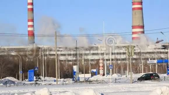 火力发电厂在阳光明媚的寒冷日子工业烟雾从管道顶着蓝天视频的预览图