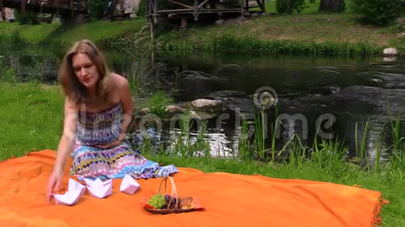 孕妇靠近河水折叠纸船视频的预览图