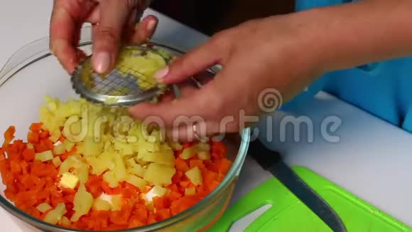 带有蔬菜和蛋黄酱的俄罗斯肉沙拉一个女人正在切煮土豆视频的预览图