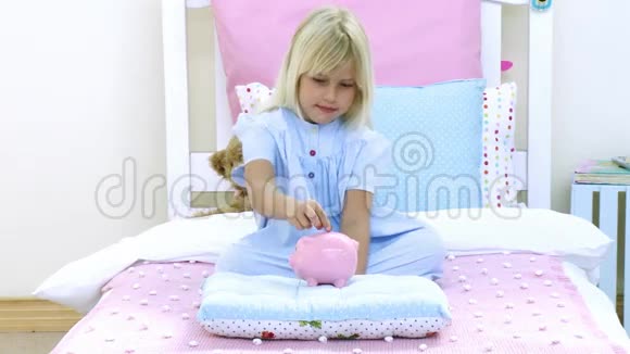 小女孩在储蓄罐里存钱视频的预览图