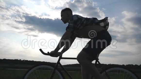 年轻男子骑着老式自行车的剪影背景是美丽的天空骑自行车的人视频的预览图