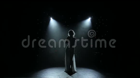 女歌手在烟雾弥漫的舞台上背光视频的预览图