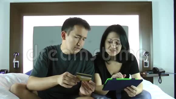 快乐的年轻夫妇在平板电脑上上网购物视频的预览图