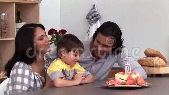 可爱的小男孩和他的父母一起庆祝生日视频的预览图