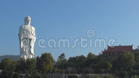 高白佛立在蓝天的背景上全景图寺庙矗立在山上视频的预览图