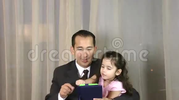 带着女儿玩数码平板电脑的男人视频的预览图