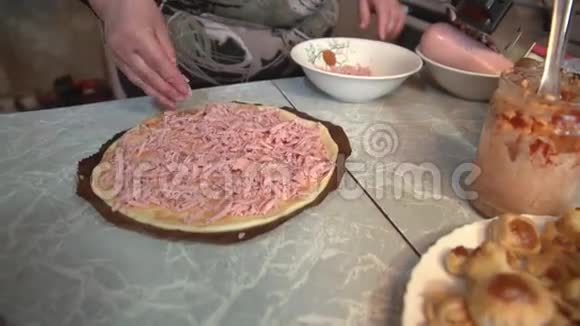 准备自制比萨饼在一个轻厨房的桌子上特写镜头视频的预览图