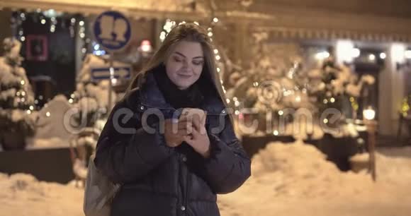 夜城街道行走时使用手机的妇女视频的预览图