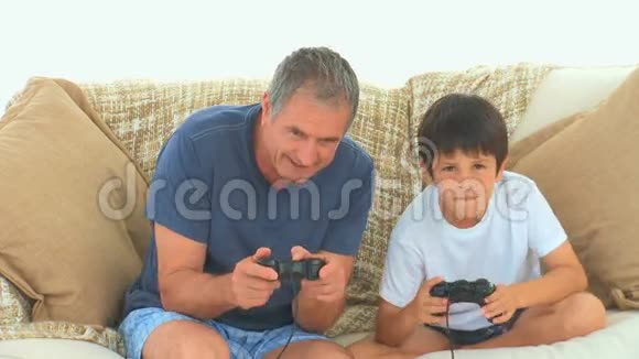 一个和祖父玩电子游戏的孩子视频的预览图