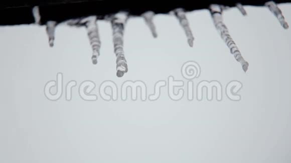 在屋顶下的春天融化冰柱冰的春天融化视频的预览图
