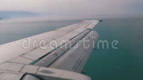从乘客飞机窗口观看飞行在海上的机翼视频的预览图