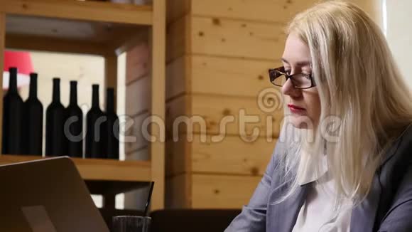 女商人在咖啡馆里吃午饭用笔记本电脑工作视频的预览图