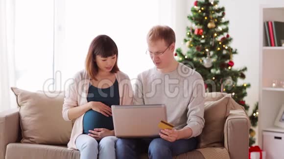 男人和怀孕的妻子在圣诞节网上购物视频的预览图
