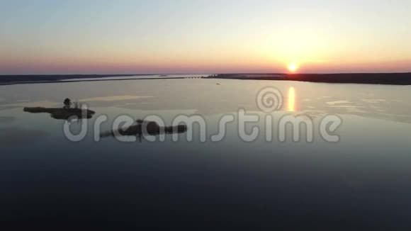 4K早春日落时乘桥飞越大型冰冻湖泊空中飞行视频的预览图