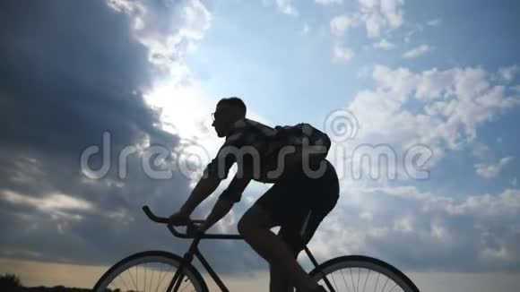 年轻人骑着老式自行车的剪影背景是美丽的日落天空骑自行车的人视频的预览图