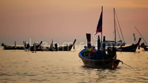 一群剪影的长尾船在太阳的金色光芒下漂浮在安达曼海上视频的预览图