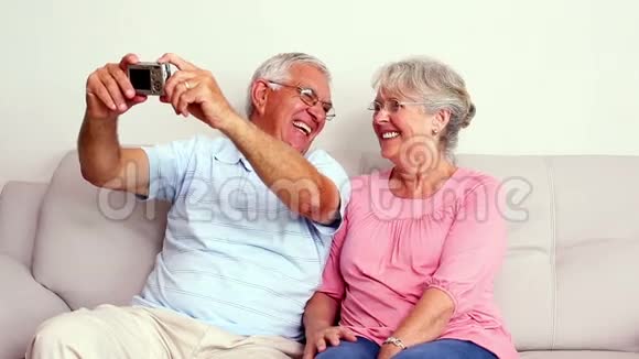 快乐的老夫妇在沙发上自拍视频的预览图