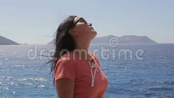 美丽的女人享受阳光和大海视频的预览图