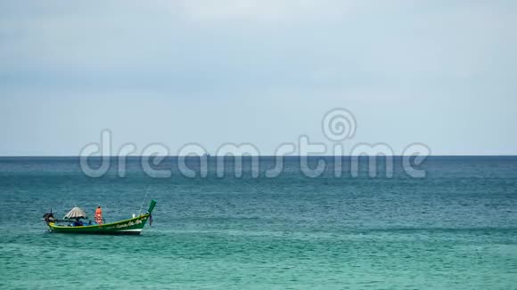 在阳光明媚的一天在热带海滩的海洋中漂流的船游视频的预览图