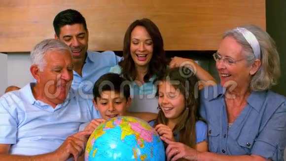 一家人一起在沙发上看地球仪视频的预览图