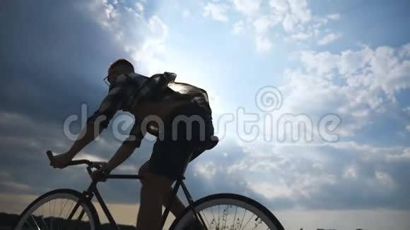 年轻人骑着老式自行车的剪影背景是美丽的日落天空骑自行车的人视频的预览图