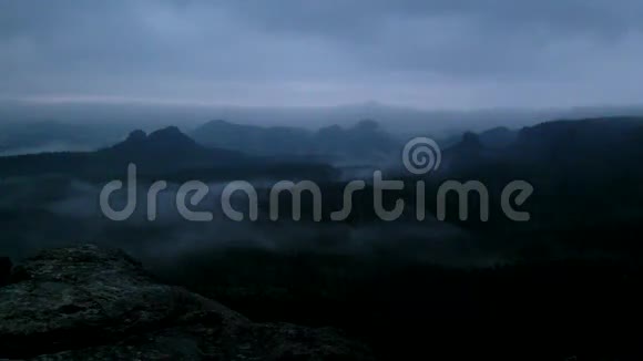 寒冷的雾蒙蒙的夜晚在萨克森州的秋天山谷瑞士公园山从朦胧的黑暗中增加视频的预览图
