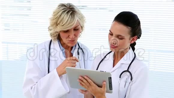 医生和护士在讨论平板电脑视频的预览图