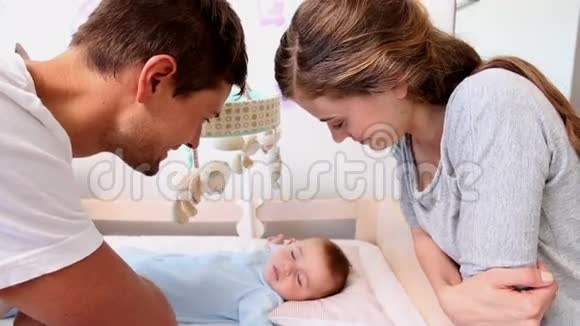 快乐的父母照看婴儿床视频的预览图