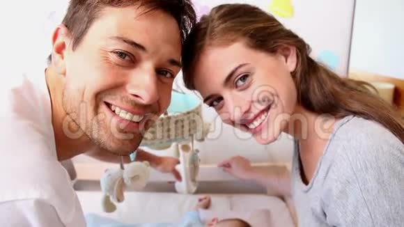 快乐的父母照看婴儿床视频的预览图