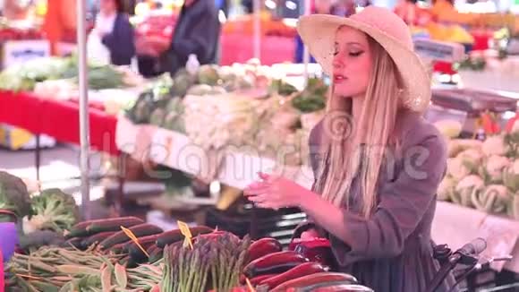 在市场上买蔬菜的漂亮女孩视频的预览图