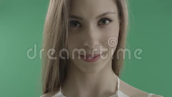 绿色背景下害羞漂亮的年轻女人视频的预览图