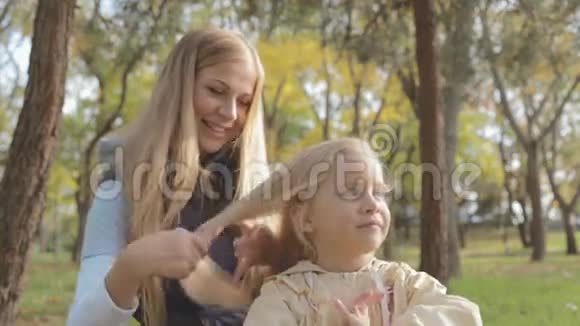 妈妈在大自然中梳理小可爱女儿的头发视频的预览图