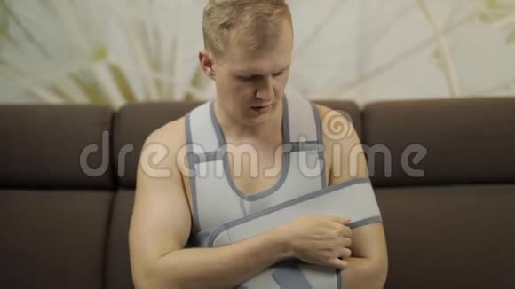 一个痛苦而无聊的男人胳膊断了手臂撑着坐在沙发上视频的预览图