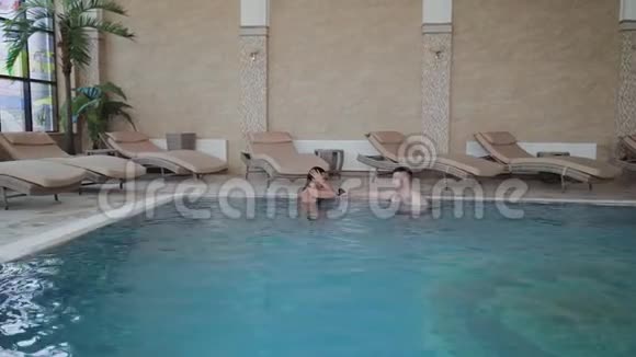 男人和女人在游泳池里游泳视频的预览图