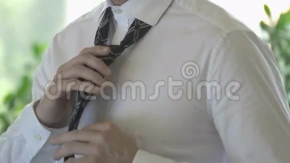 一个穿着白衬衫的商人在系领带视频的预览图
