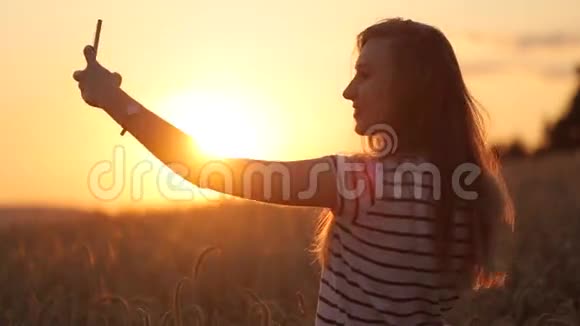 赛尔夫在日落时拍摄一个女孩的慢动作视频视频的预览图