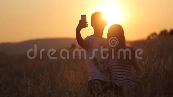 自拍拍摄一个女孩和男人在日落慢动作视频视频的预览图