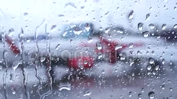 飞机窗户上的雨滴和外面模糊的机场视频的预览图