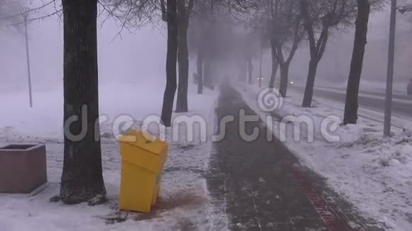 大雪纷飞的街道上黑沉沉的晨雾视频的预览图