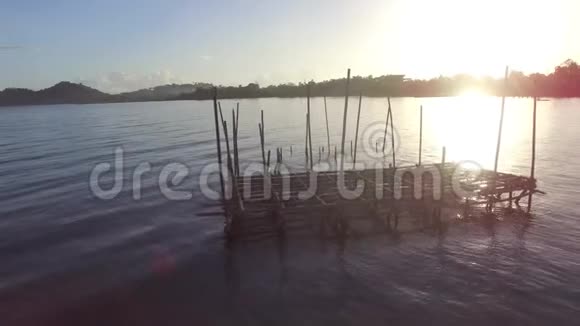 太阳升起在湖中央的竹子结构上视频的预览图