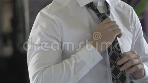 一个穿着白衬衫的商人在系领带视频的预览图