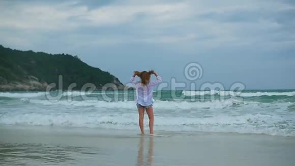 一个年轻女孩沿着海滩散步视频的预览图